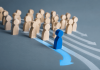 Every Pharma Campaign Looks the Same. Here’s How to Break Away Blue figure breaking away from a group, representing brand differentiation strategy in pharma marketing.