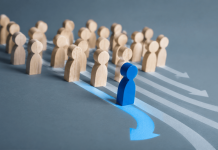 Every Pharma Campaign Looks the Same. Here’s How to Break Away Blue figure breaking away from a group, representing brand differentiation strategy in pharma marketing.