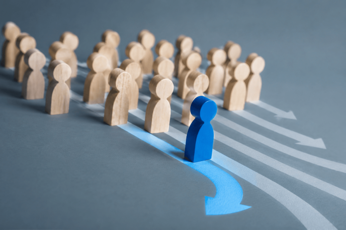 brand-differentiation-strategy-pharma-marketing Blue figure breaking away from a group, representing brand differentiation strategy in pharma marketing.