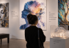 Epilepsy Is Hard to Put Into Words. UCB Is Trying Art Instead. Visitor viewing epilepsy-inspired artwork in a gallery, illustrating experiential disease education through art and lived experience.