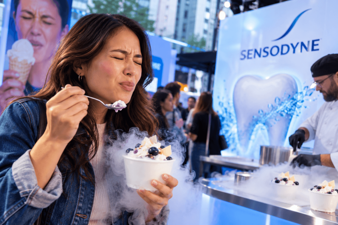 sensodyne-experiential-healthcare-marketing-frozen-treat Woman reacting to an extremely cold frozen dessert at a Sensodyne experiential marketing activation highlighting tooth sensitivity.